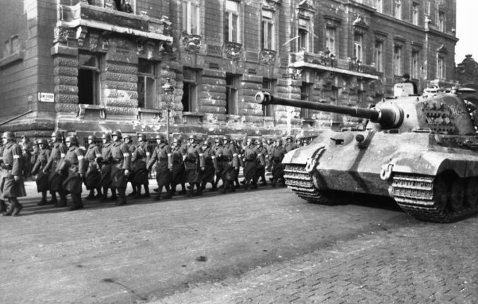 Hungarian militia from the Arrow Cross Party pass a german Tiger II in Budapest, October 1944.